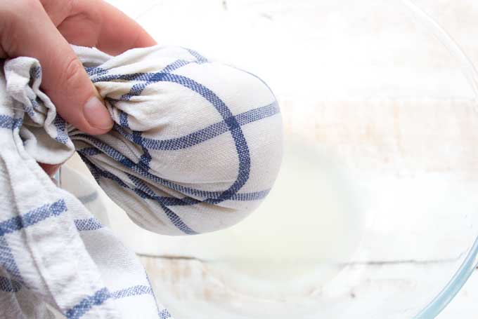 squeezing liquid out of cauliflower with a dishcloth