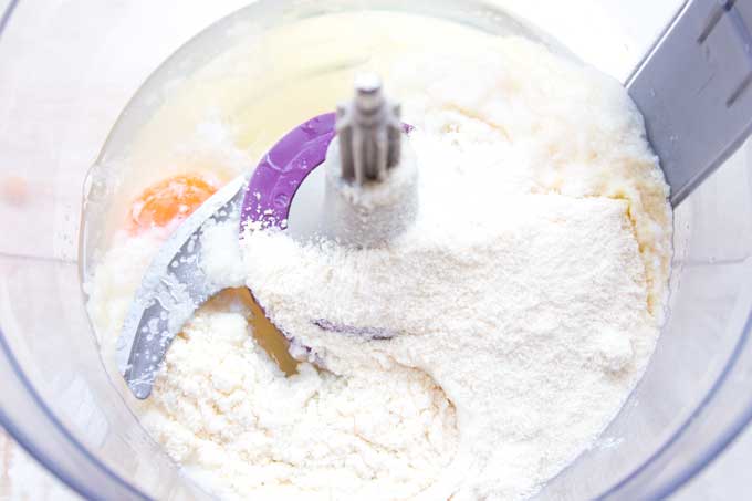 Wet and dry ingredients in a food processor before mixing.