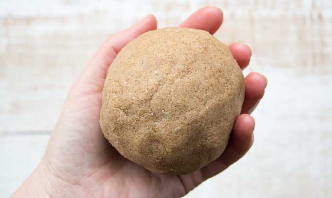 a hand holding the dough for Keto cinnamon crunch cereal