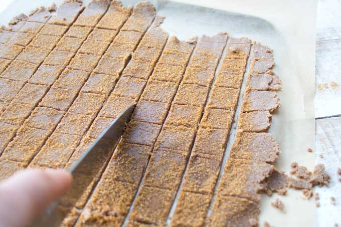 A knife cutting the rolled out dough for Keto cinnamon crunch into squares