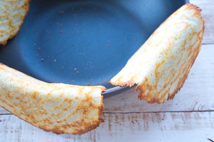 Cooling the Keto taco shells by hanging them over the rim of a large saucepan