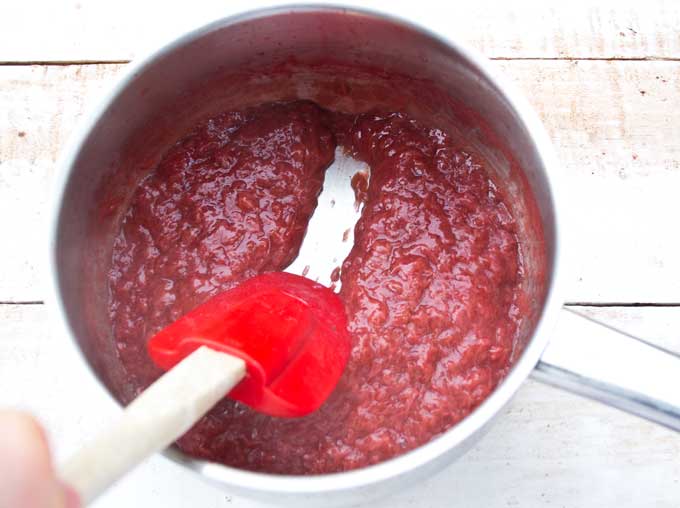 cooked strawberry jam in a saucepan with a spatula