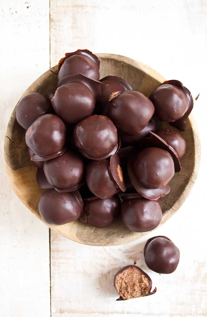 keto almond butter truffles dipped in chocolate in a wooden bowl