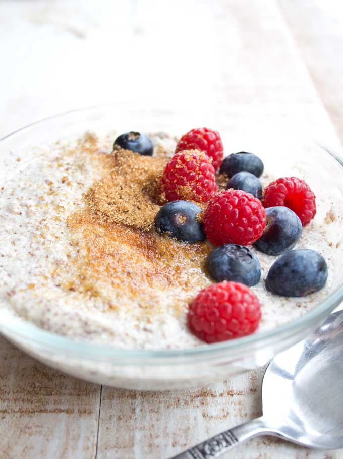 a bowl of keto low carb porridge with golden erythritol and berries
