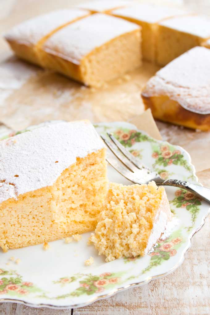 a Keto lemon bar slice on a plate with a fork