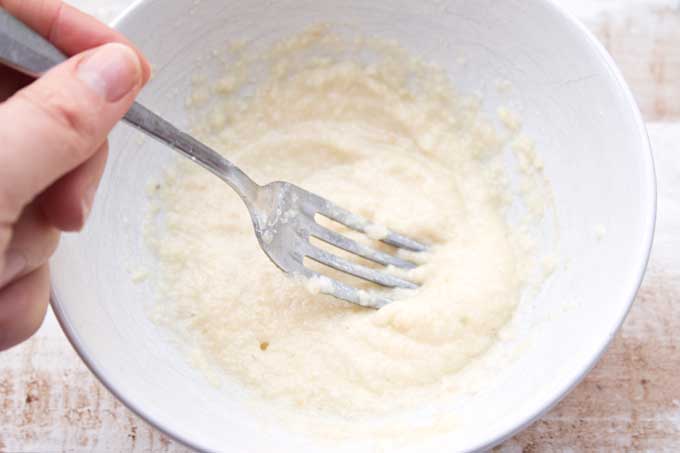 batter in a bowl being mixed with a fork