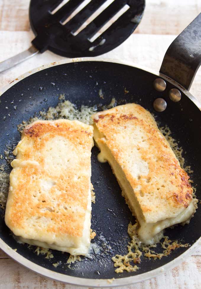 90 second keto bread cut into half and turned into cheese toasties in a frying pan