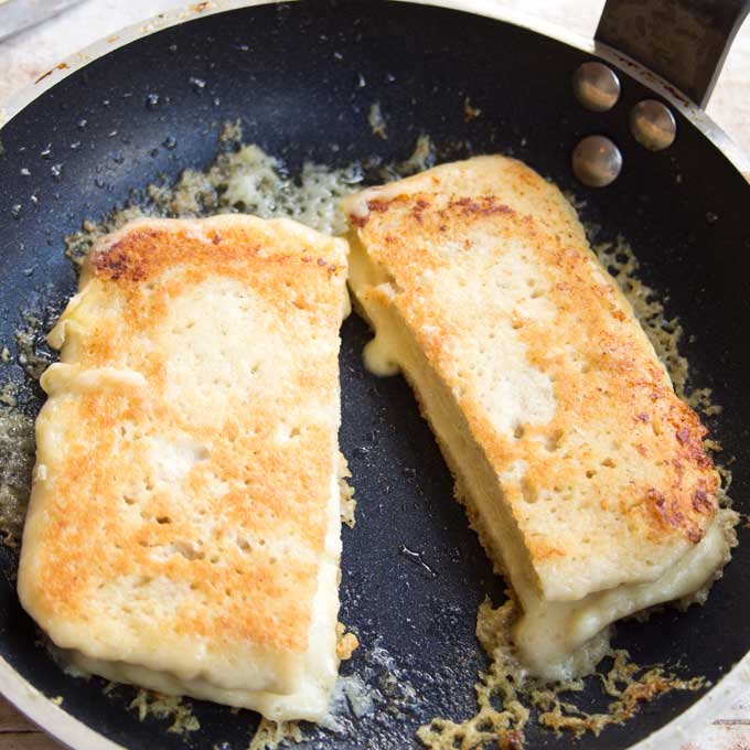 two slices of keto Microwave bread filled ith melted cheese in a frying pan