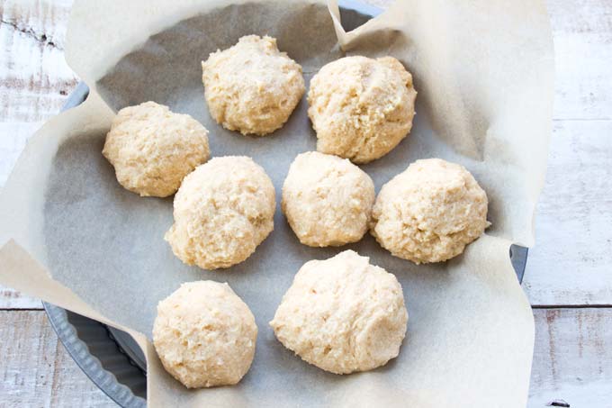 keto bread rolls before rising in a baking tray and parchment paper