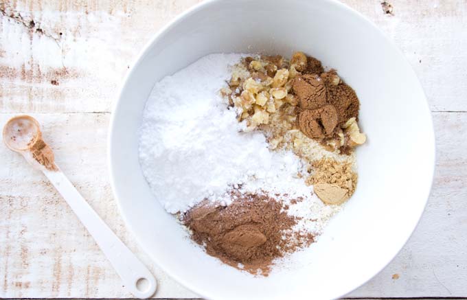 Dry ingredients in a white bowl and a spoon on the side.