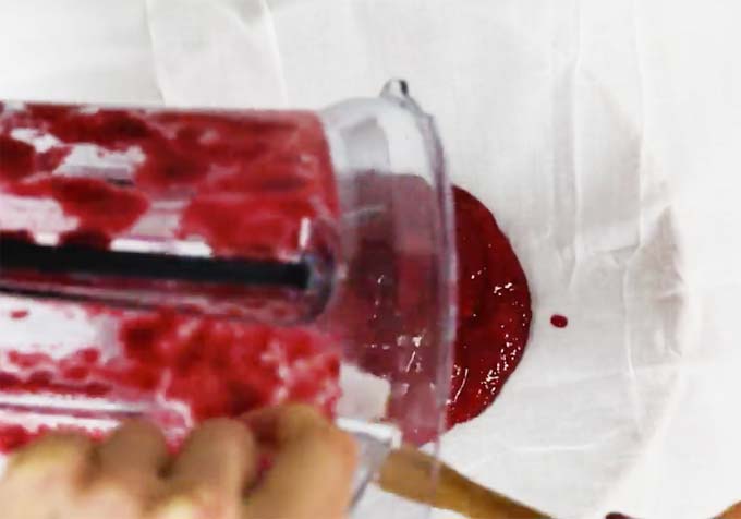 pouring berry juice onto a muslin cloth