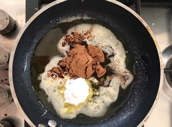 cacao powder and powdered erythritol added to a pan with liquid cacao butter