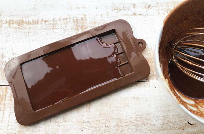 melted cocoa mass in a brown silicone chocolate mould