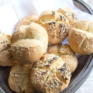 A silver tray with baked rolls topped with a mix of poppy seeds and sesame seeds