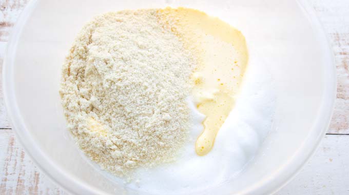 egg white and egg yolk in a mixing bowl plus almond flour