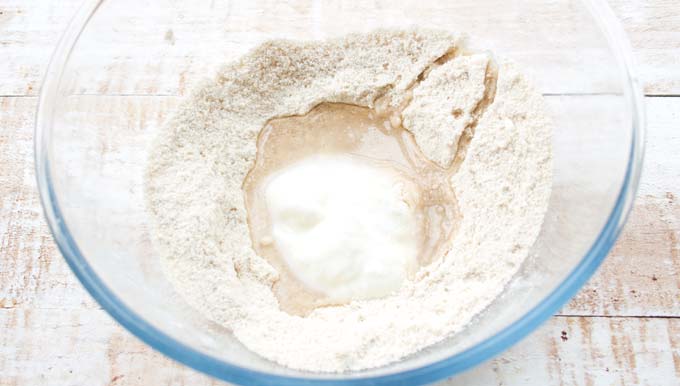 a glass bowl with coconut flour, yogurt and coconut oil 