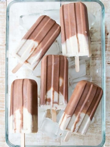 peanut butter and chocolate popsicles in a glass bowl on ice