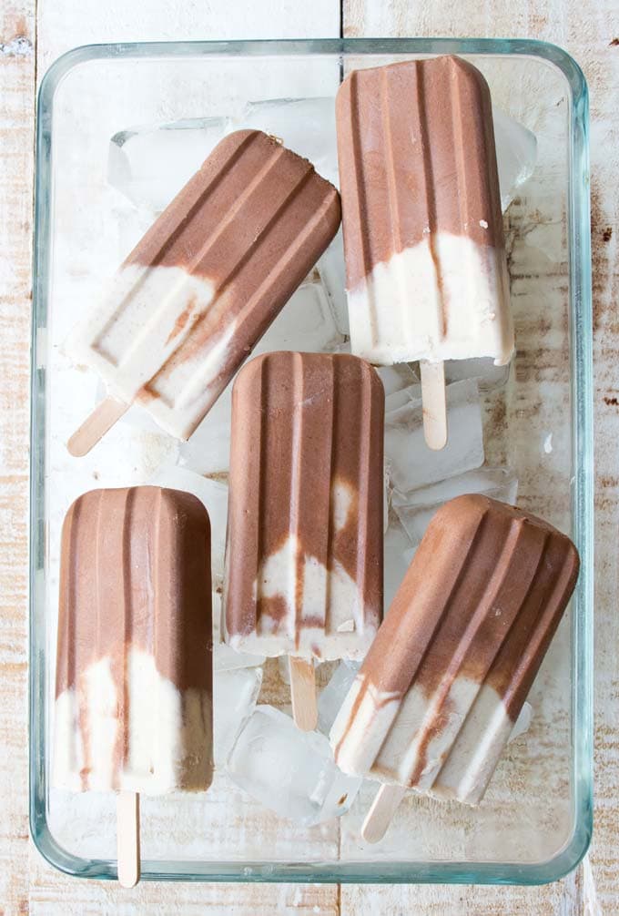 peanut butter and chocolate popsicles in a glass bowl on ice