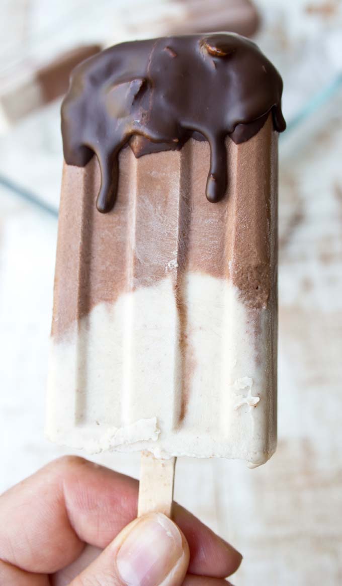 hand holding a sugar free peanut butter ice pop with chocolate coating