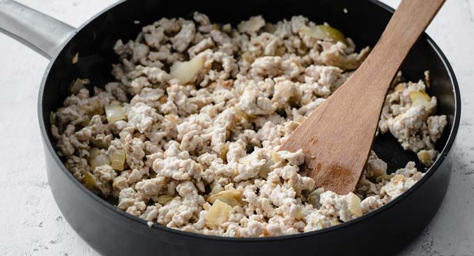 turkey mince and onions in a frying pan with a spatula
