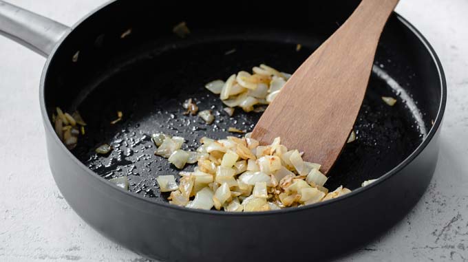 chopped onion in a frying pan with a spatula
