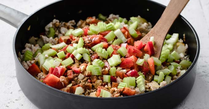 chopped vegetables and ground meat in a pan with a spatula