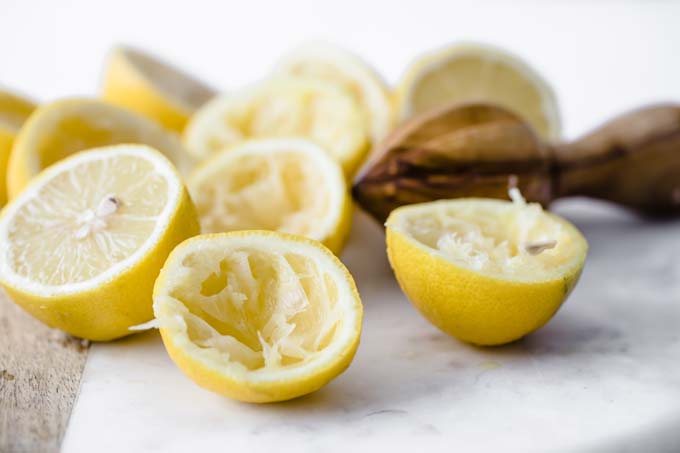 juiced lemon halves and a lemon juicer