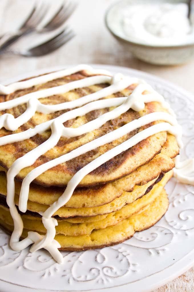 A stack of pancakes with cream cheese frosting.