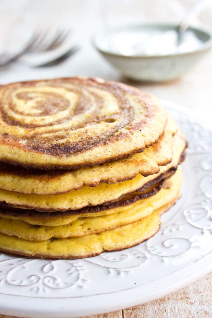 a stack of cinnamon swirl pancakes on a white plate
