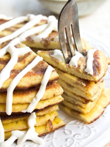 A stack of cinnamon swirl pancakes with cream cheese frosting.
