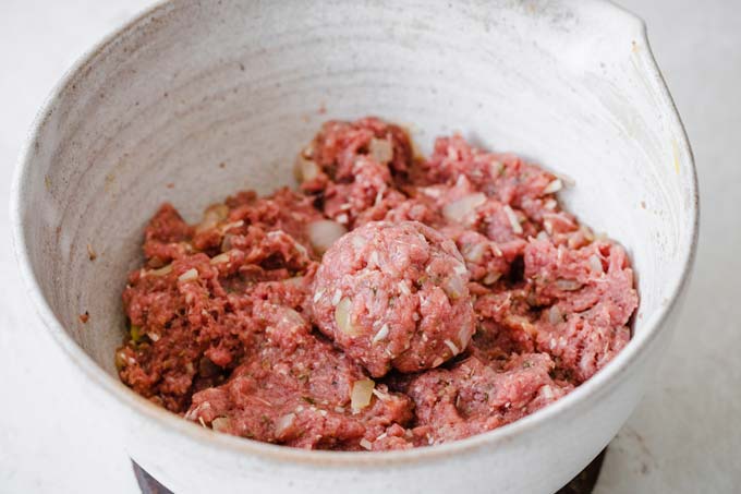 forming meatballs out of raw beef mince in a bowl