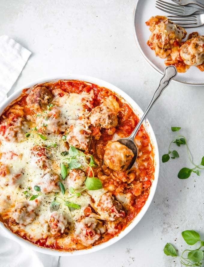 A casserole dish filled with Keto meatballs in a tomato sauce and topped with melted cheese