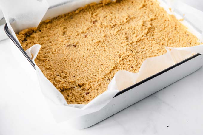 Pumpkin batter in a baking pan lined with parchment paper.