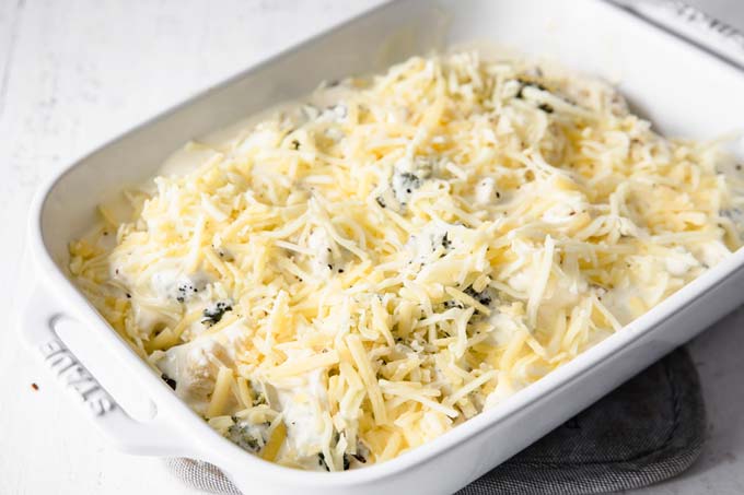 cauliflower and broccoli florets topped with cheese sauce and shredded cheese before baking