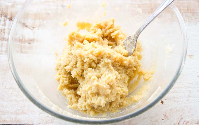 Dough in a mixing bowl and a fork.