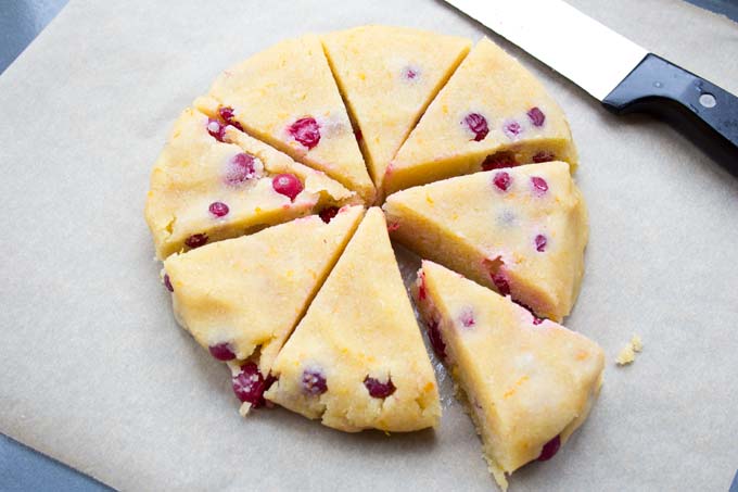 unbaked cranberry orange scones with a knife on a baking sheet
