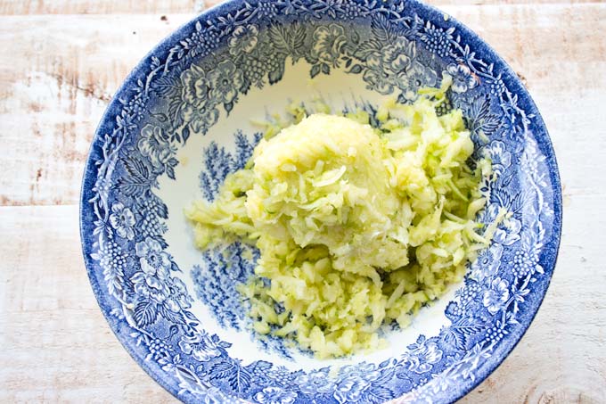 grated zucchini with the liquid squeezed out in a bowl