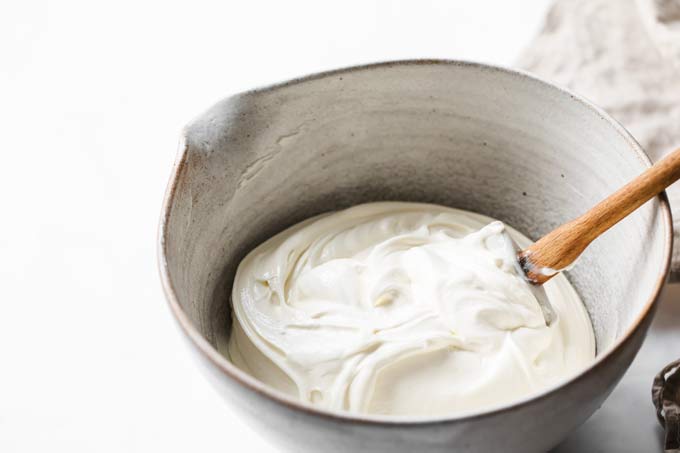 cream cheese and mascarpone cheesecake mix in a mixing bowl with a spatula