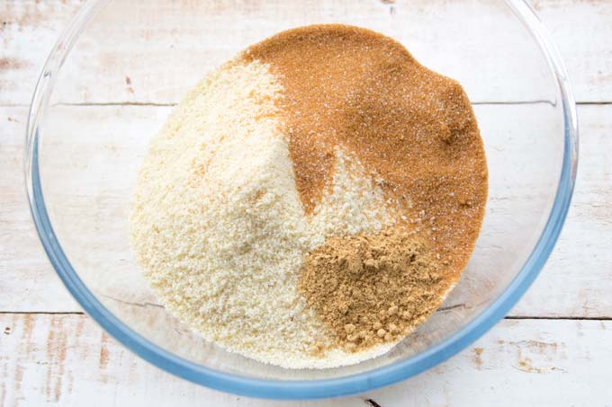 A bowl with almond flour, brown erythritol and spices.