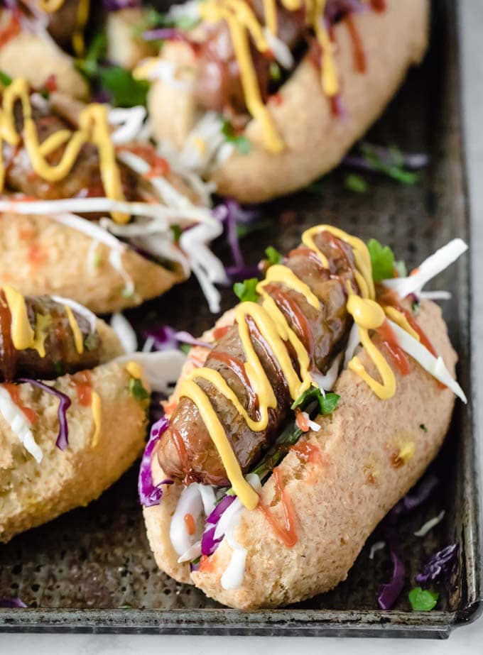 low carb hot dog buns filled with sausage, salad and mustard and ketchup