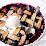 keto skinny mixed berry pie with a scoop of vanilla ice cream and a spoon