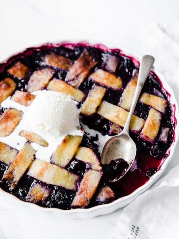 keto skinny mixed berry pie with a scoop of vanilla ice cream and a spoon