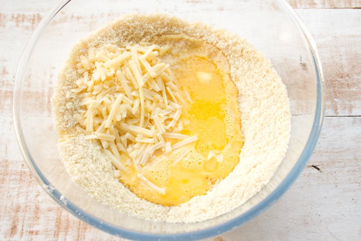 almond flour, eggs, butter and grated cheese in a bowl