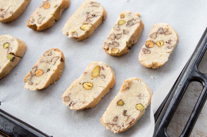 Sliced biscotti on a baking tray lined with greaseproof paper.