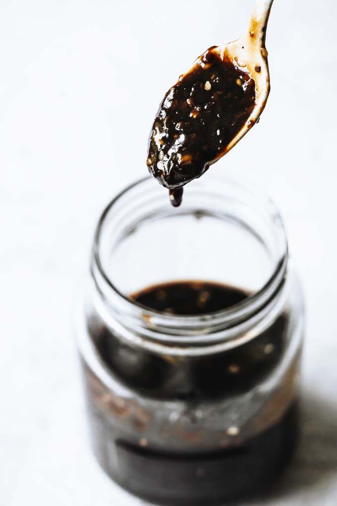 thick keto teriyaki sauce dripping from a spoon into a glass jar