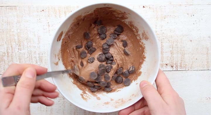 mixing chocolate chips into chocolate dough with a fork