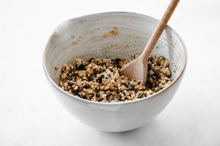 a nut and seed mix in a bowl with a spoon