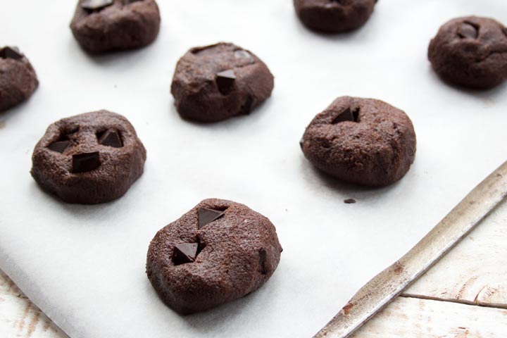 unbaked chocolate chip cookies on a baking tray lined with parchment paper