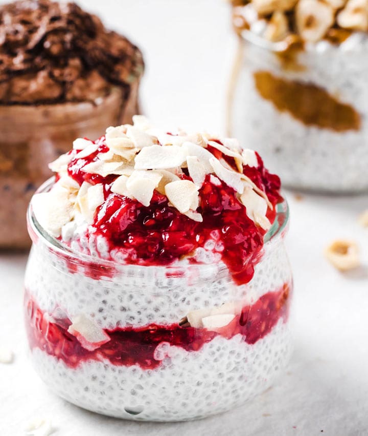 a chia pudding with raspberry sauce in a glass jar