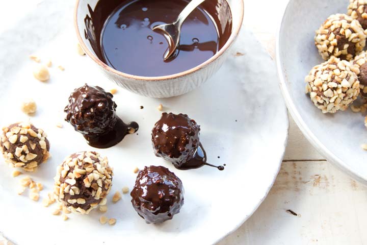 coating chocolate truffles rolled in chopped hazelnuts in melted chocolate